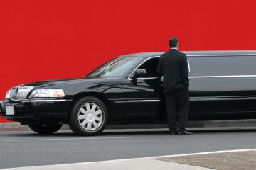 Elegant black stretch limousine with driver.